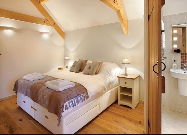 A pine-beamed double bedroom with adjoining ensuite bathroom.