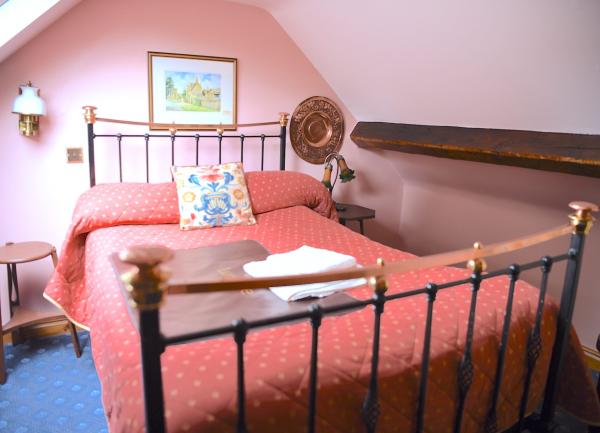 Double bedroom with brass bed and twin bedside tables with lamps.
