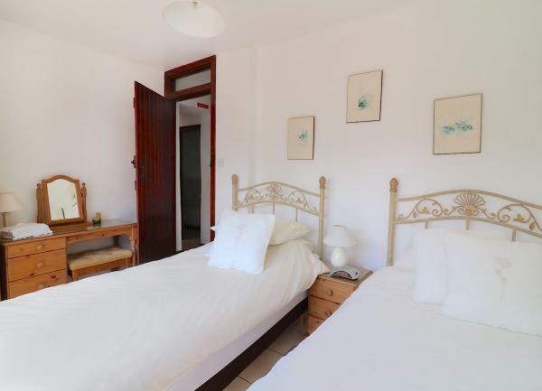 A twin bedroom with beds and a bedside table.