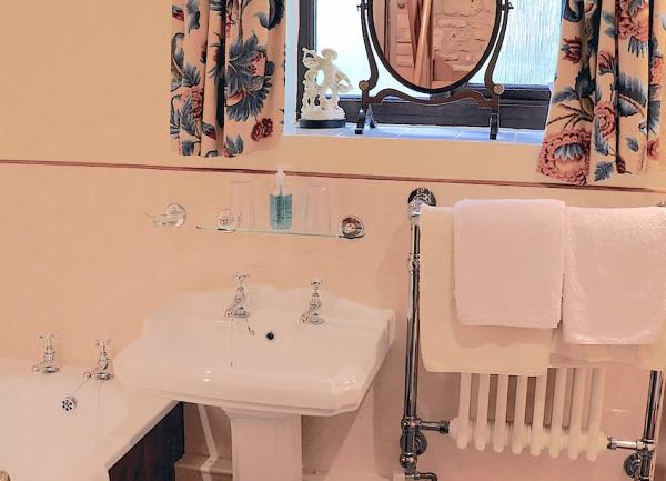 Bathroom with bath, washbasin and heated towel rail.