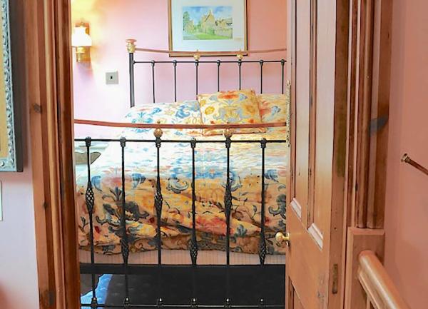 A double bed seen through an open doorway from a landing.