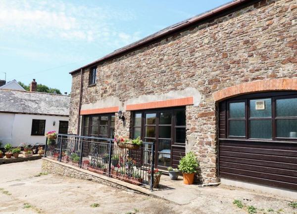 Exterior of a converted barn with large French windows.