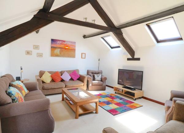 Spacious, oak-beamed lounge with sofa, TV and coffee table.