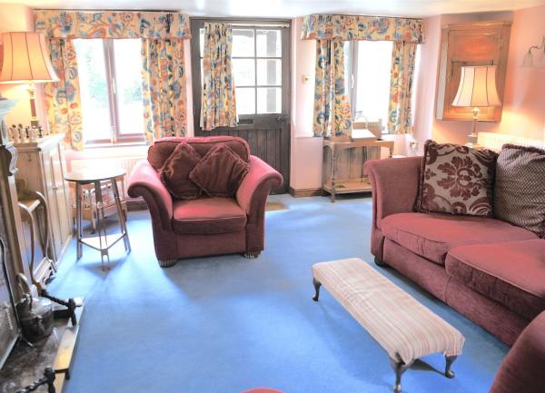 Sitting room with a sofa, armchair and footstool.
