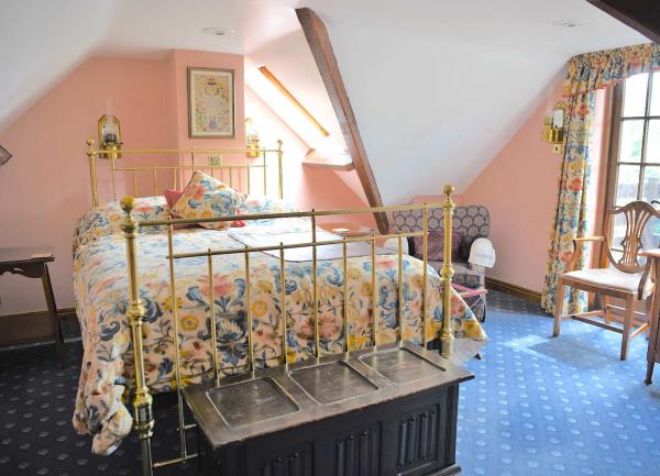 Bedside tables and armchairs, double bedroom with brass bed.