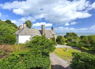 A stone-built country cottage for couples overlooks a large and sunny lawn.