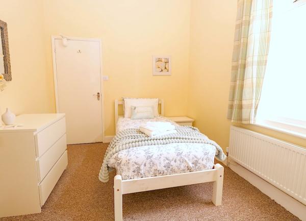 Single bedroom with bed and chest of drawers.