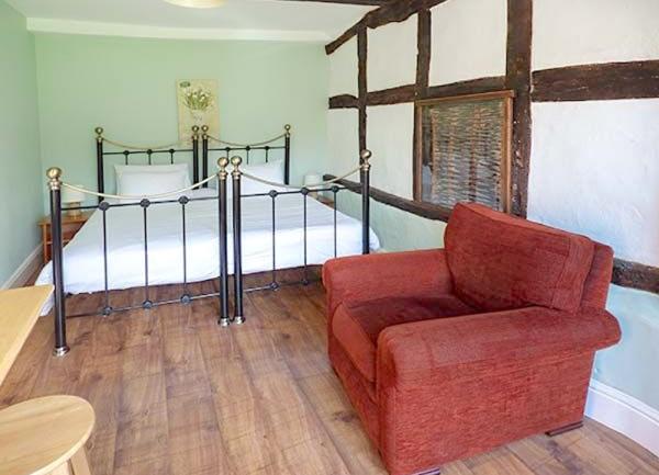 Bedroom with zip-and-link bedroom with both beds linked, and an armchair.