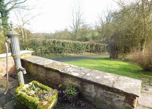 A viere of a garden from a low-walled patio.