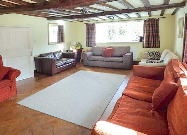 An oak-beamed lounge with sofas on 3 sides.