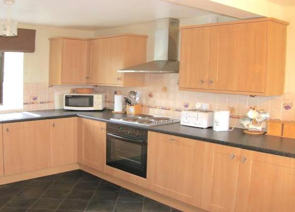 A fitted kitchen with integrated oven and worktop appliances.