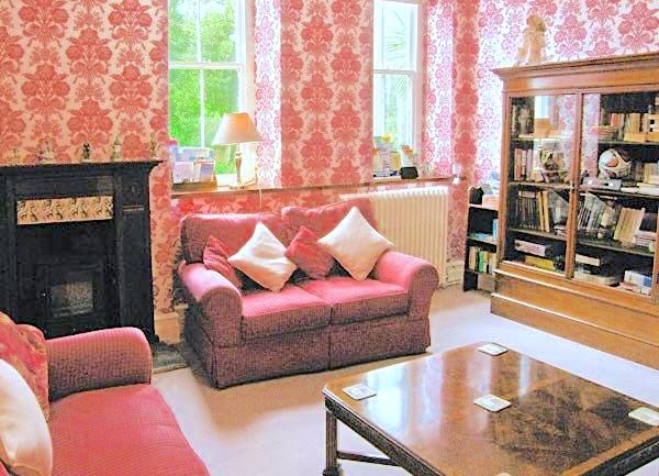 Sitting room with sofas, book case and coffee table.