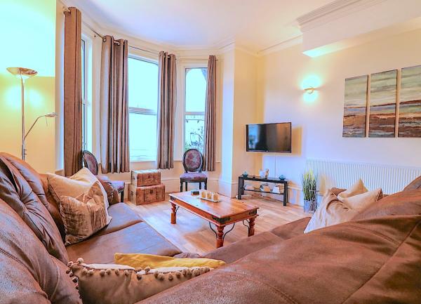Lounge with bay windiows, sofas, coffee table and TV.