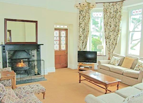 Lounge with sofas, armchair, wood burner and coffee table.