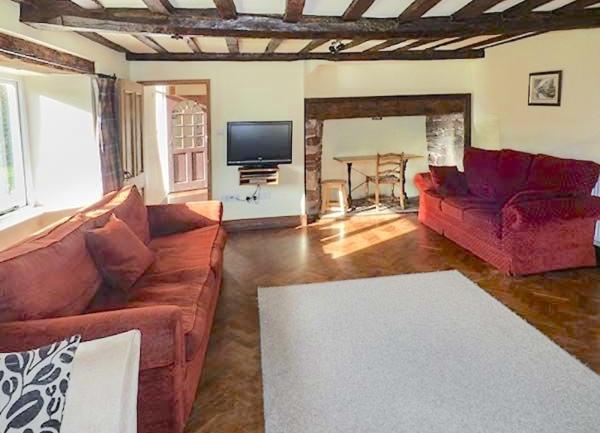 Lounge with wall-mounted TV and alcove with a card table.