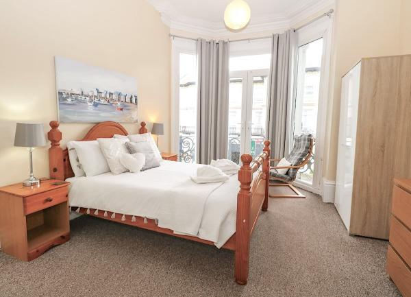 Double bedroom with a bay window, bed, bedside cabinets and a wardrobe.
