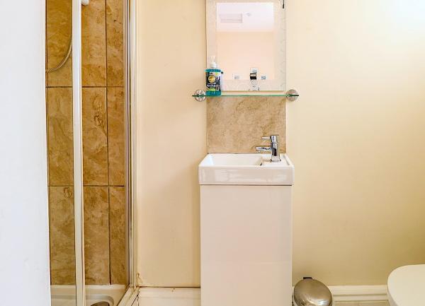 An ensuite bathroom with a shower, wash basin and WC.