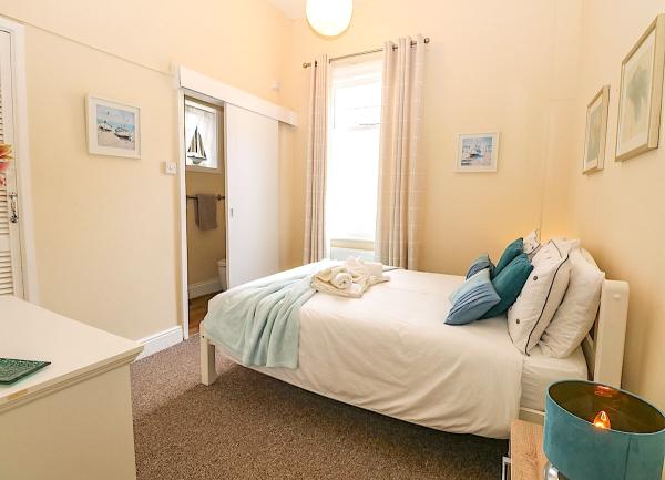 Double bedroom with a fitted wardrobe, TV and bedside cabinets with table lamps.