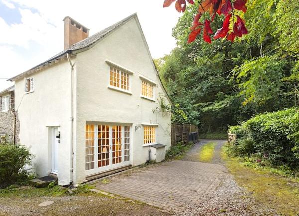 Gable end of a 2 storey cottage facing a wood.