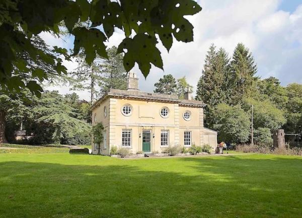 A house surrounded by a large, well-maintained lawn and a sweeping drive.