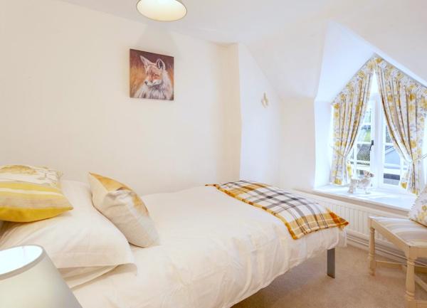 Double bedroom with bedside chair and a cottage window with a window seat.