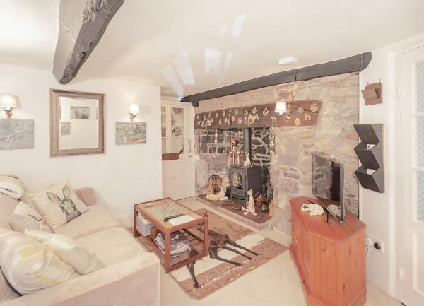 A louunge with an inglenook fireplace, sofa and coffee table