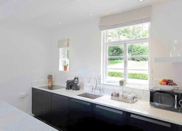 A kitchen worktop with a sink, radio and microwave.
