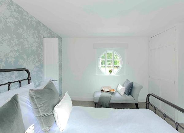 Double bedroom with a bed and small chaise lounge.