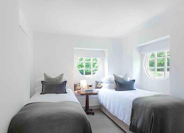 Dual aspect twin bedroom with beds and a bedside table.