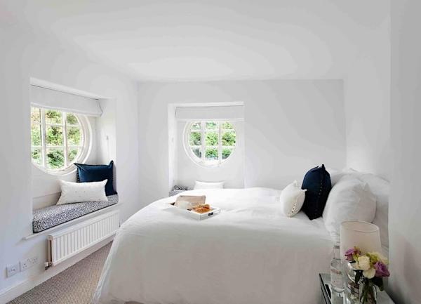 Dual aspect double bedroom with large bed and bedside tables with table lamps.