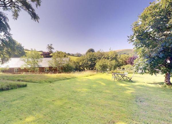 Large rear garden with trees and a picnic table and chairs, rural views