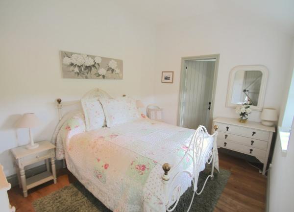 Double bedroom with bed, chet of drawers, dressing table and twin bedside tables with table lights .