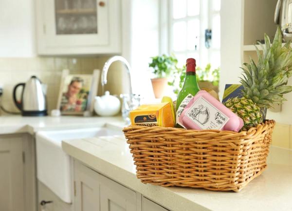 A welcome hamper of food and drink for guests on a kitchen worktop.
