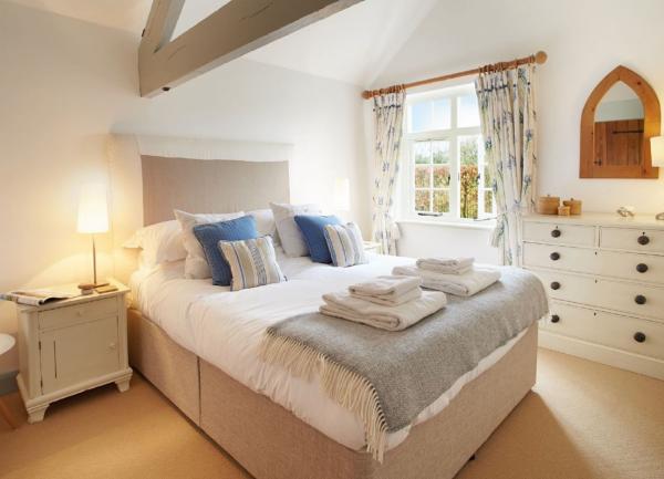 A double bedroom with a bed, twin bedside cabinets, bedside cabinets with lamps and a chest of drawers.
