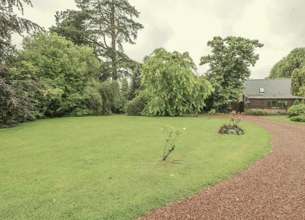 The front lawn bordered by a sweeping shingled driveway.