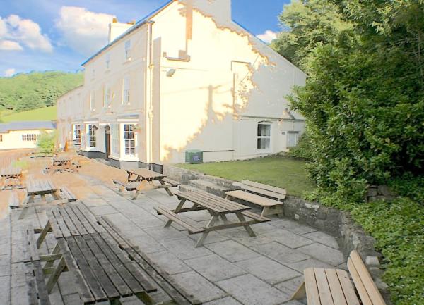 A sunny paved terrace with 7 picnic benches at the rear of the house.