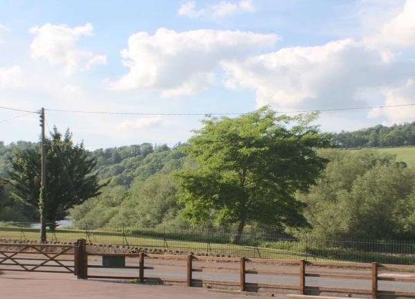 Across the road in the foreground the River Wye winds between open fields.