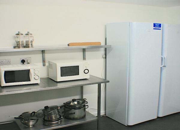 Kitchen c with two microwaves and two tall fridges.