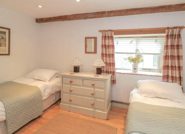 An oak-beamed bedroom with a double bed and twin bedside tables with lights.