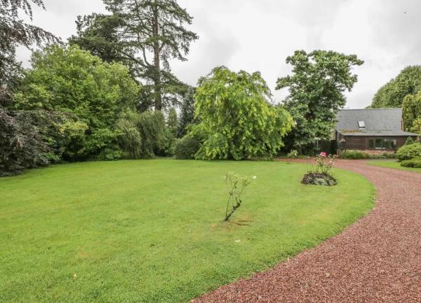 A shingle drive. circles round a tree-lined front lawn.