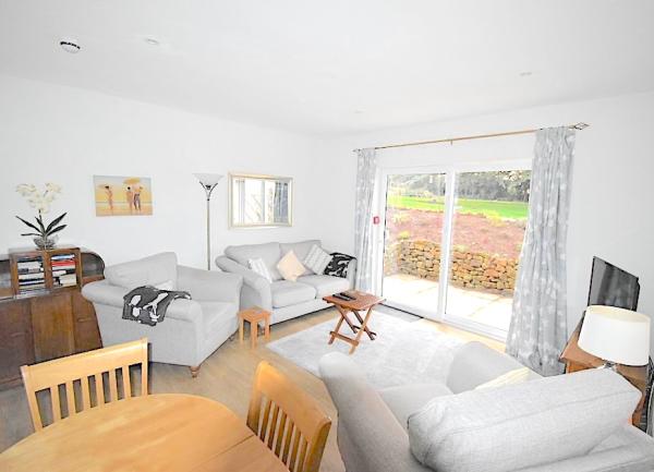 Lounge-Diner with 3-piece suite, TV, Sideboard, dining table and sliding glass door to garden.