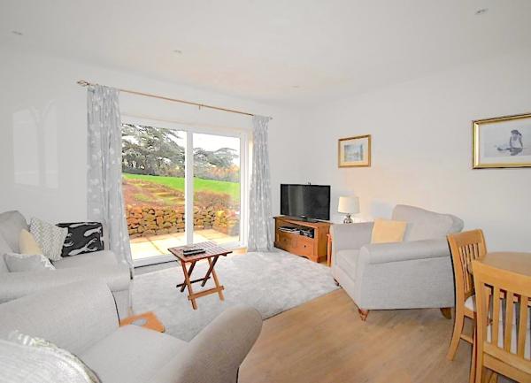 Lounge with scenic countryside views through sliding glass doors.