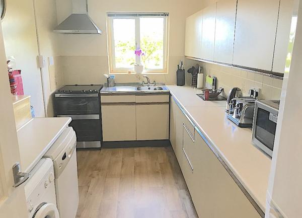 Fitted kitchen with wall and floor cupboards, oven, washing machine, dishwasher and fridge-freezer.