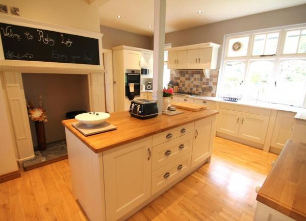 Kitchen with fitted units and a wide-screen wall-mounted TV.