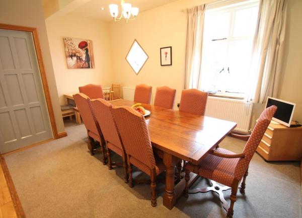 Dining room with a table seating 8 and a TV in the room's corner.