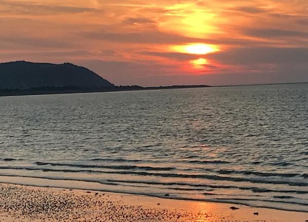 Sunset at high tide on a sandy beach in Somerset.