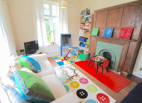 Children's play room with infant table and chairs and shelves with games.
