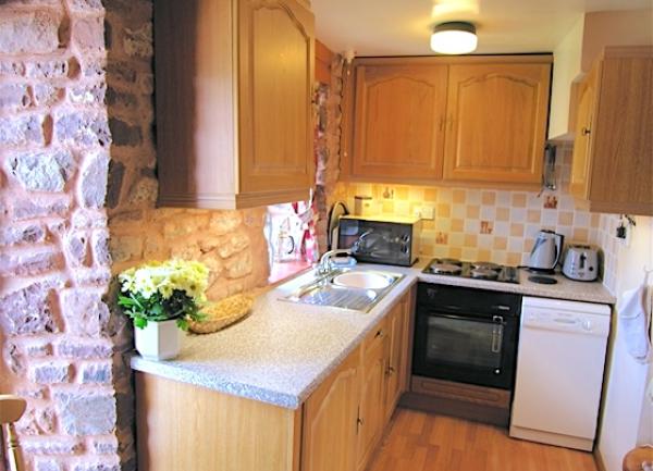 A Minehead cottage kitchen with modern oven and dishwasher.