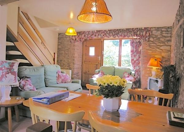 A cosy Minnehead rural cottage lounge with a polished wooden dining table.