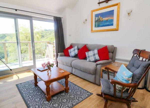 Cottage lounge with a sofa, rocking chair, coffee table and rural views.